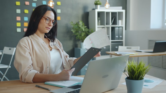 Compliance reviewer checking documents at an office desk